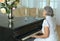 Elderly woman playing the piano at home