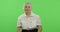 An elderly woman points at the camera and smiles. Old grandmother. Chroma key