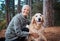 Elderly woman, portrait and hiking with dog in forest and fitness, travel and pet with love and care. Nature, trekking