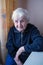 Elderly woman portrait near window in the house