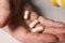 An elderly woman pours pills from a jar into her hand. Elderly health concept. Nursing and caring for elderly parents.