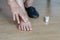 Elderly woman putting cream on swollen feet