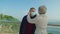 Elderly woman putting on medical mask on bearded husbands face