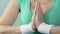 Elderly woman putting palms together at her chest, practicing yoga, close-up