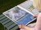 Elderly woman reading Self-isolate To keep me safe advertisement, issued by HM Government and NHS, in national newspaper.