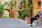 Elderly woman rests on a chair in the street in Pienza