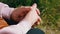 Elderly Woman Rubbing Wrinkled Hands, Sitting in Nature in the Rays of Sunlight