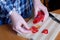 An elderly woman\'s hands chop red bell peppers