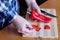 An elderly woman\'s hands chop red bell peppers