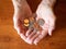 Elderly Woman`s Hands Holding Multiple Coins