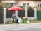 An elderly woman sells vegetables and fresh fruits on the roadside in a suburb of Bucharest, Romania.