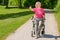 Elderly woman sits in wheeled walker on park path