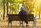 Elderly woman sitting on a bench in autumn park