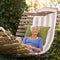 Elderly, woman and sleep on hammock during retirement and relax on summer vacation with happiness. Garden, senior person