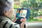 An elderly woman speaks with a doctor via video chat while sitting on her balcony.