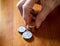 Elderly Woman Stacking Coins on a Wooden Table