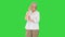 Elderly woman standing with crossed hands on a Green Screen, Chroma Key.