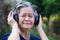 Elderly woman standing wearing wireless headphone listening to a favorite song, and smile happy in garden. Asian senior woman,