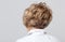 An elderly woman stands with her back and shows her hairstyle after cutting and dyeing her hair in a beauty salon. Hairdressing