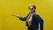 Elderly Woman. Stylish Elderly Woman On Yellow Background. She Is Wearing Hat And Glasses. She Goes Dancing Past Yellow