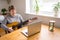 An elderly woman takes guitar lessons online. A retired senior woman studying online, watching music lessons at home on