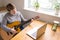 An elderly woman takes guitar lessons online. A retired senior woman studying online, watching music lessons at home on