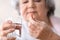 Elderly woman taking pill, closeup