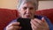 Elderly woman using a mobile phone. Happy smiling grandmother holds a smartphone