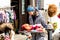 Elderly woman vendor selling socks, woolen slippers and bright souvenirs on the street of Signagi town, Kakheti region, Georgia