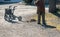 Elderly woman with walker, rakes the lawn and doing gardening work