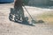 Elderly woman with walker, rakes the lawn and doing gardening work