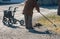 Elderly woman with walker, rakes the lawn and doing gardening work