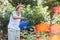 Elderly woman watering plants in her garden