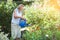 Elderly woman watering plants in her garden