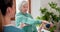 Elderly woman with weights for exercise with physiotherapist at physical therapy clinic for rehabilitation. Female