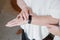 An elderly woman in a white blouse is wearing a fitness bracelet. Smart watch on the hand of an old woman. Pensioner Using Fitness