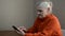 Elderly woman writes a message in a smartphone