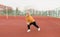 An elderly woman in a yellow jacket is doing sports exercises on a red treadmill. the stadium is a healthy lifestyle. retired