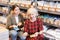 Elderly woman and young woman choose shade of paint from palette