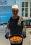 Elderly Women holding large cooking pan in home kitchen