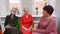 Elderly women sit and talk on friend meeting in pensioners club.