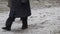 Elderly women walk through the first snow on a forest path.