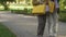 Elderly women walking together with shopping bags in park, female friendship