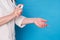 Eldery caucasian doctor lady in white coat and with stethoscope on blue background. Close up of using antiseptic