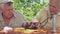 Eldery people examine hedgehog sitting at wooden table