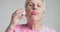 Eldery woman blow bubbles to camera