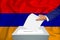 Elections in the country - voting at the ballot box. A mans hand puts his vote into the ballot box. Flag Armenia on background