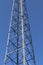 Electric antenna and communication transmitter tower in a northern european landscape against a blue sky