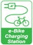 Electric bicycle charging station sign with text and silhouettes of electric plug and e-bike.