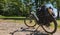 Electric bicycle with load and an attached smartphone for navigation is parked on a gravel road next to a meadow